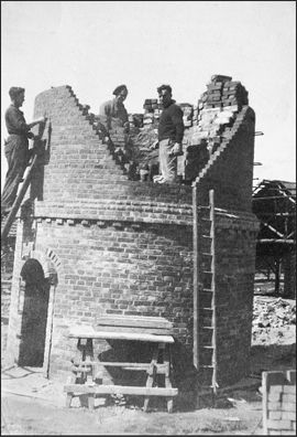 Groepje metselaars bij een in aanbouw zijnde schoorsteen